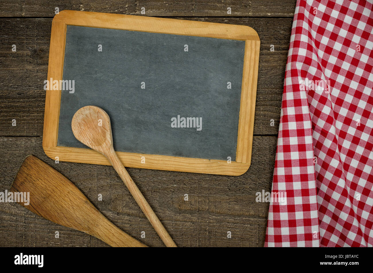 Leere Schiefertafel Mit Kochlöffeln Und rot Karierten Tischtuch Stockfoto