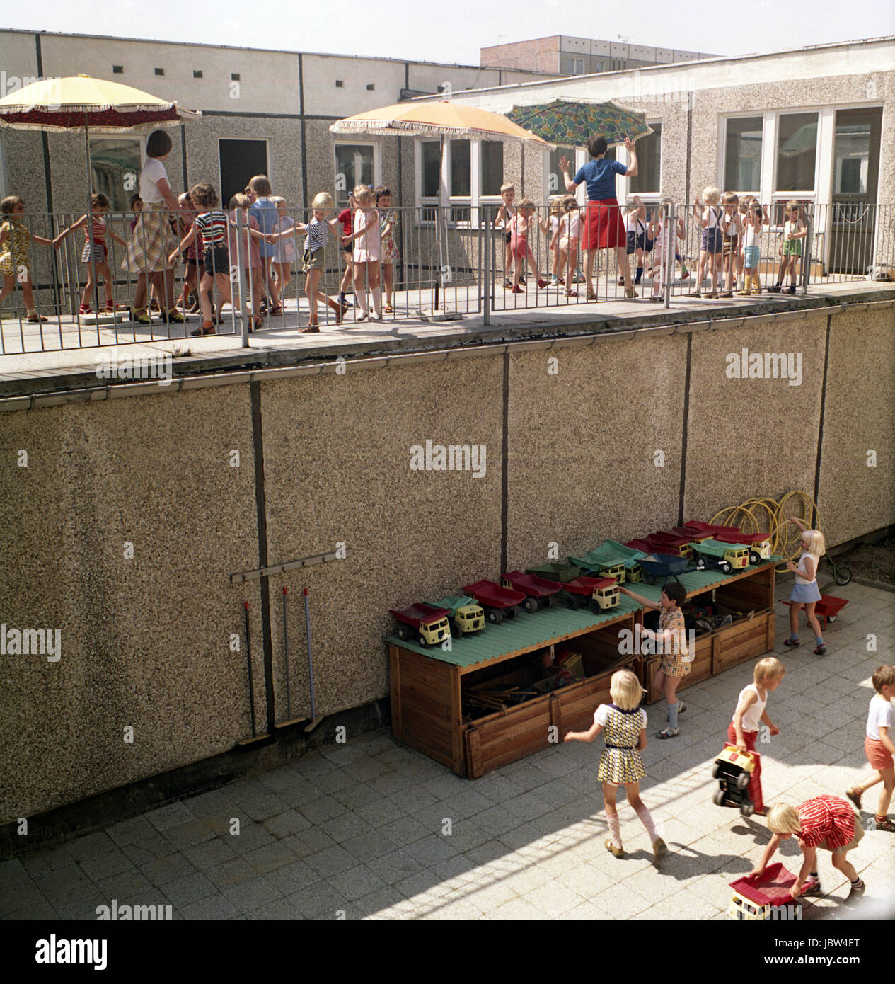 Rostock, DDR, spielen die Kinder mit ihrer Gouvernante auf der Terrasse des Kindergartens Stockfoto