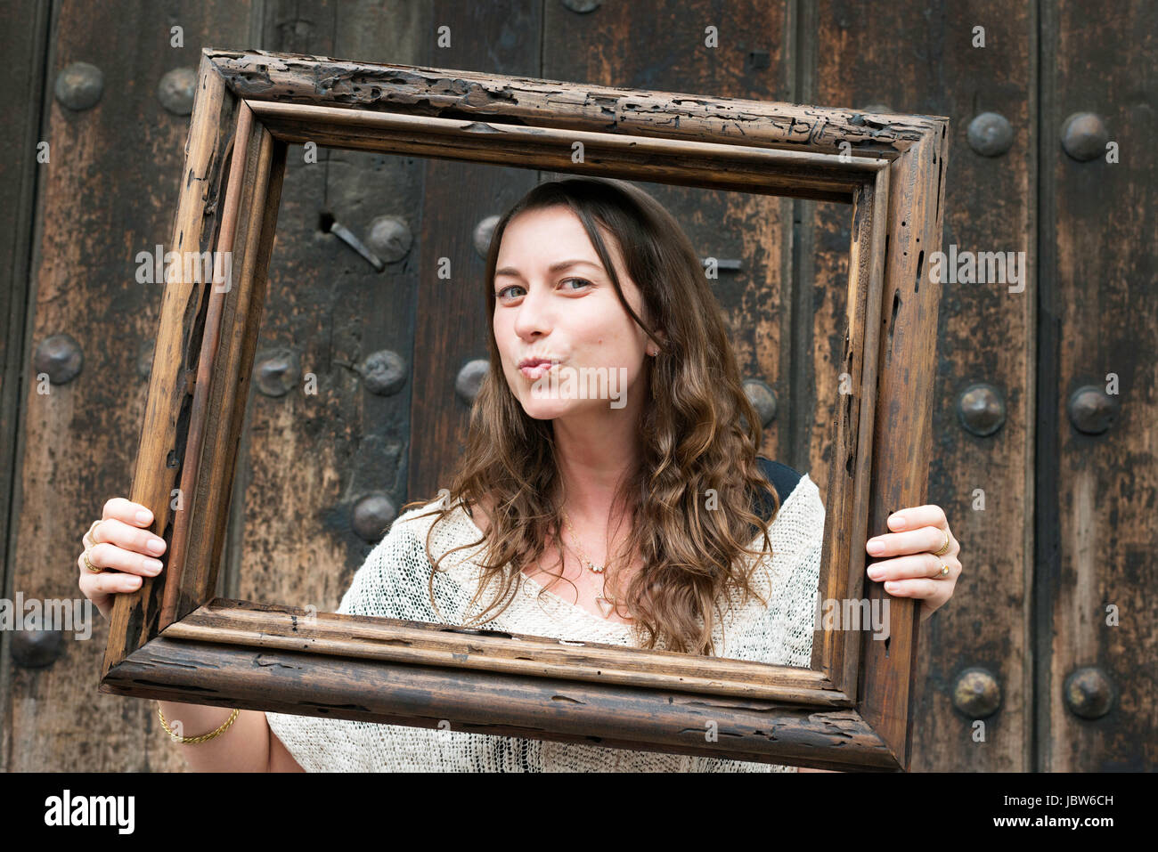 Porträt von Mitte Erwachsene Frau, hält Holzrahmen vor Gesicht, Mexico City, Mexiko Stockfoto