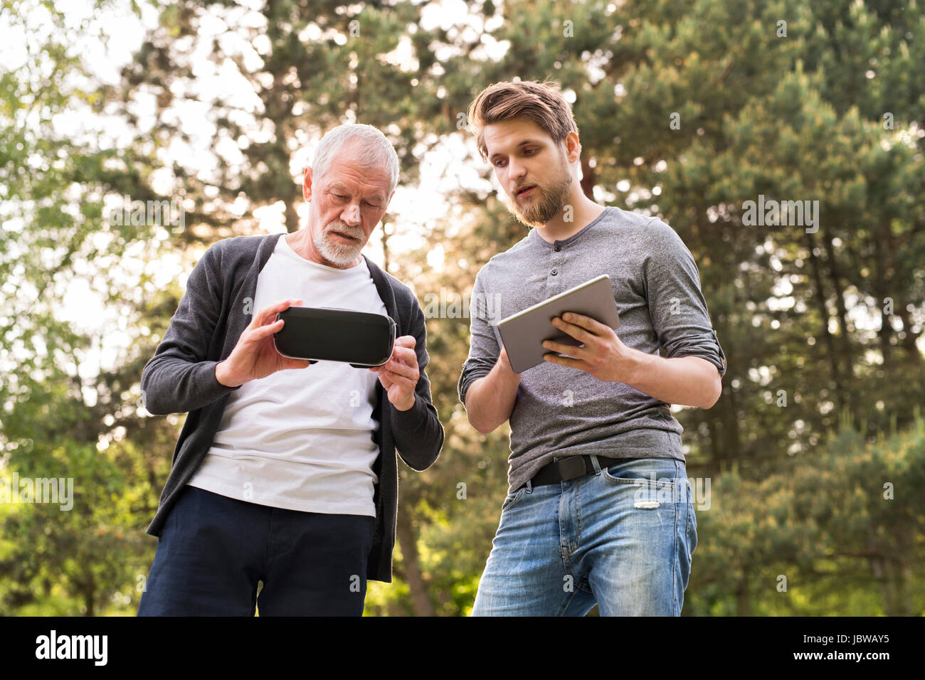Junger Mann und Vater senior mit VR-Brille im Freien. Stockfoto