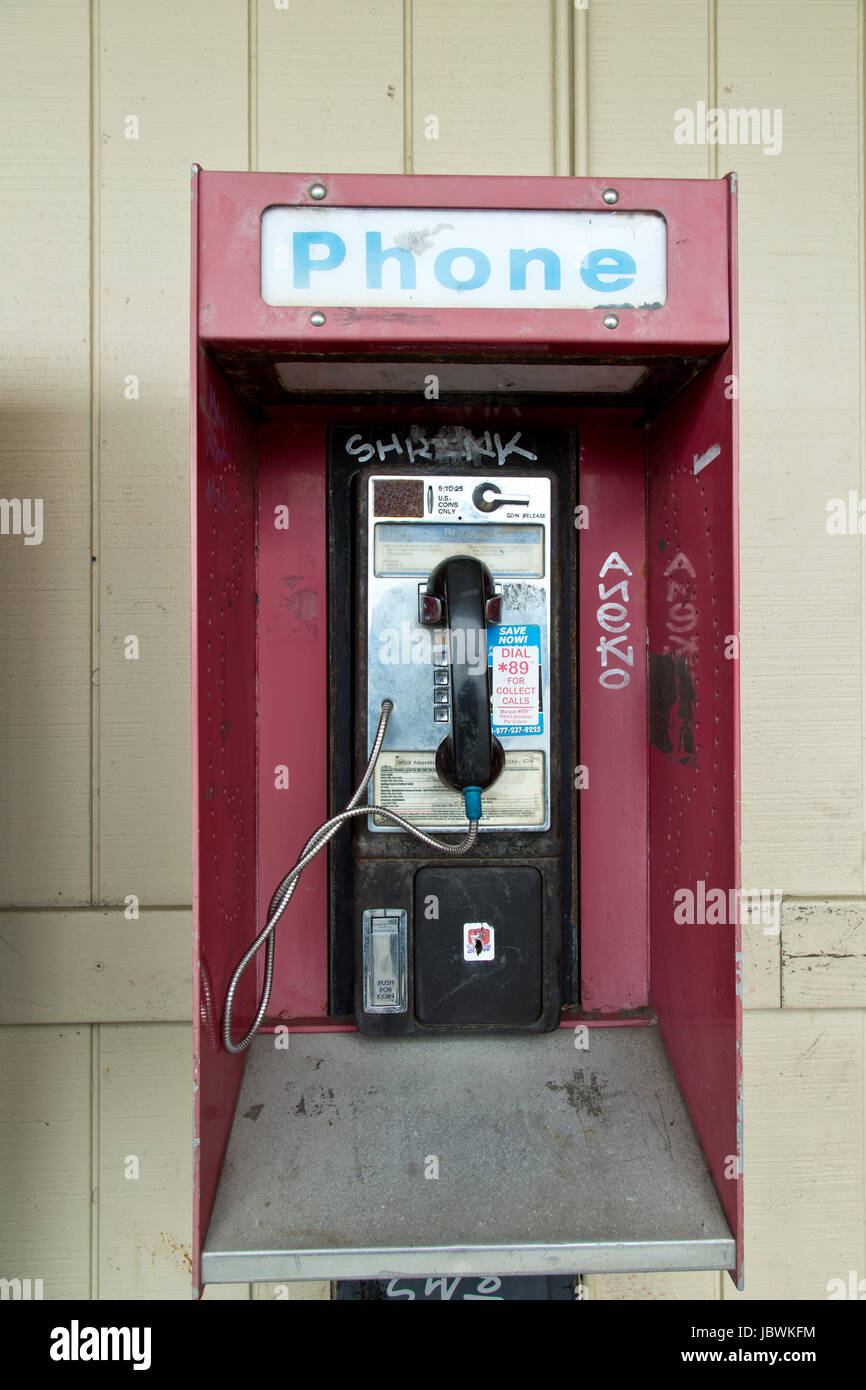 Abgebrochene Münzautomaten öffentliche Telefonzelle mit Münze release Slot, alten Shopping Center. Stockfoto