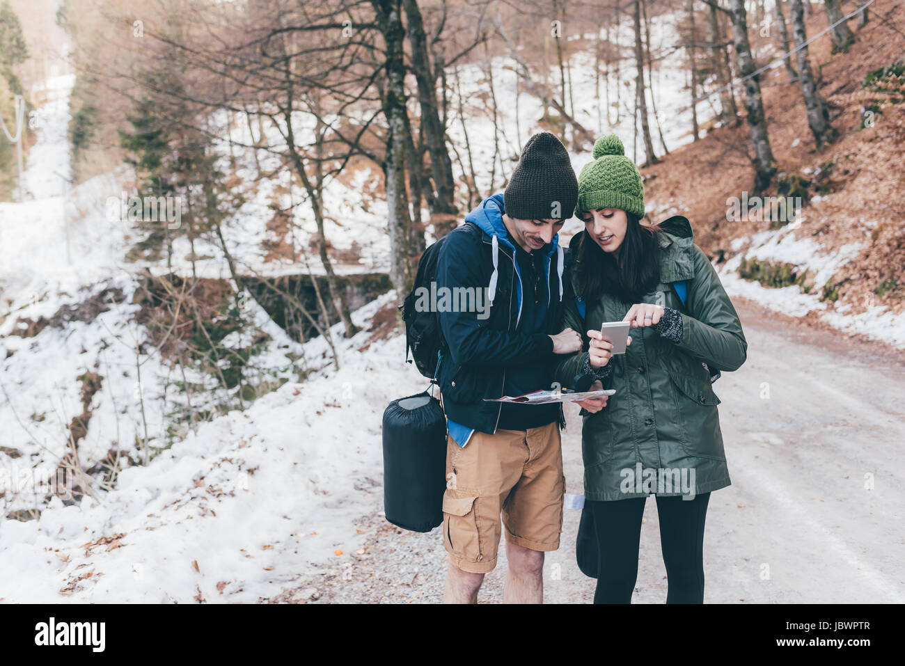 Wandern-paar auf verschneiten Waldweg Blick auf Smartphone, Monte San Primo, Italien Stockfoto