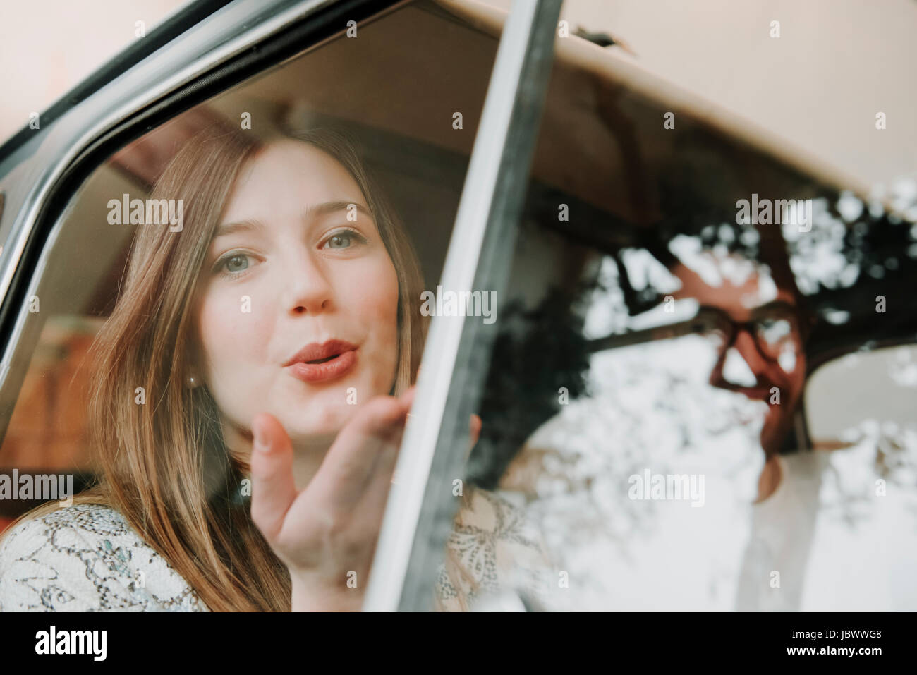 Paar in Passagiere Sitz des Autos, Frau weht Kuss Stockfoto