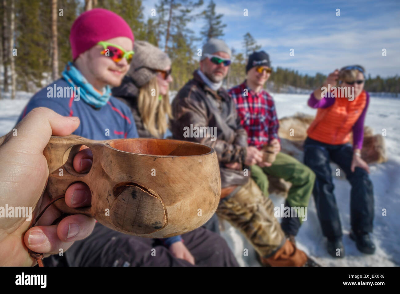 Leute sitzen um ein Lagerfeuer, Kangos, Lappland, Schweden Stockfoto