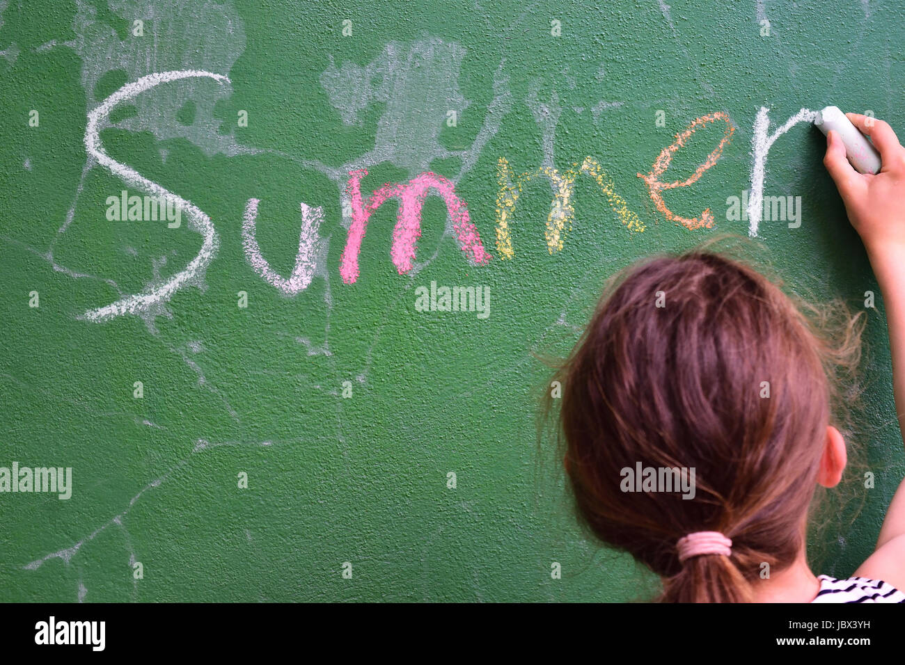 Das Wort "Sommer" von einem Mädchen auf einem grünen Brett geschrieben Stockfoto