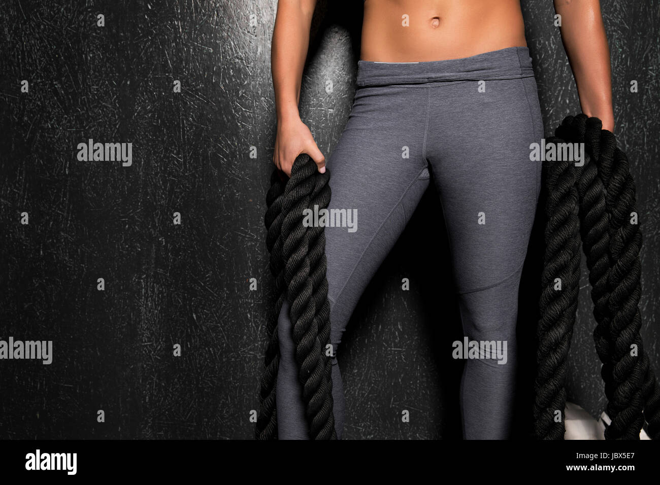 Junge Frau im cross-Fit Fitnessstudio trainieren mit Seil Stockfoto