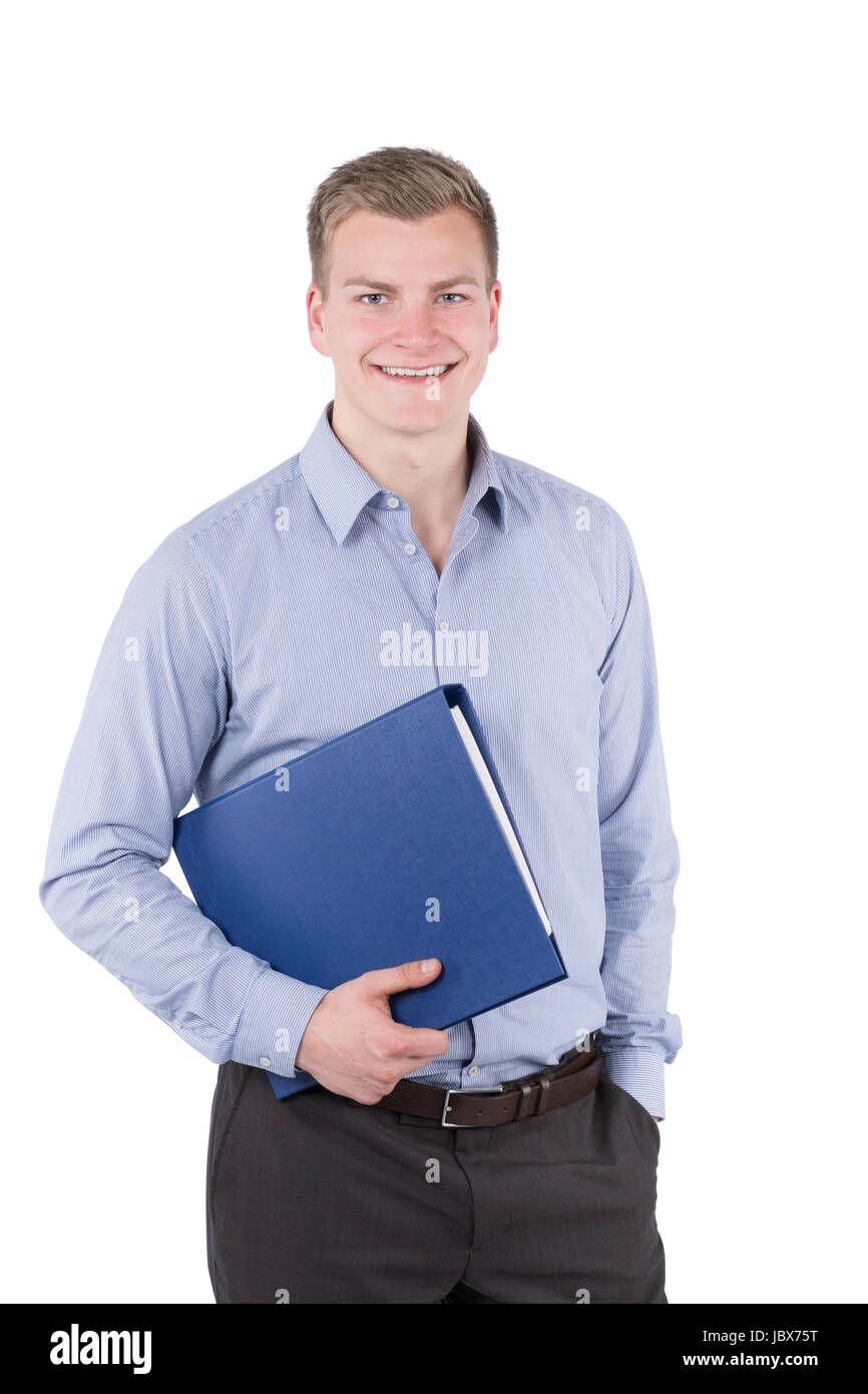 Freigestelltes Foto Eines Jungen, Lächelnden Geschäftsmannes, der Einen Blauen Aktenorder Unter seit Arm Trägt Und Die Andere Hand in Seiner Hosentasche Hut. Der Mann Schaut Zur Kamera. Stockfoto