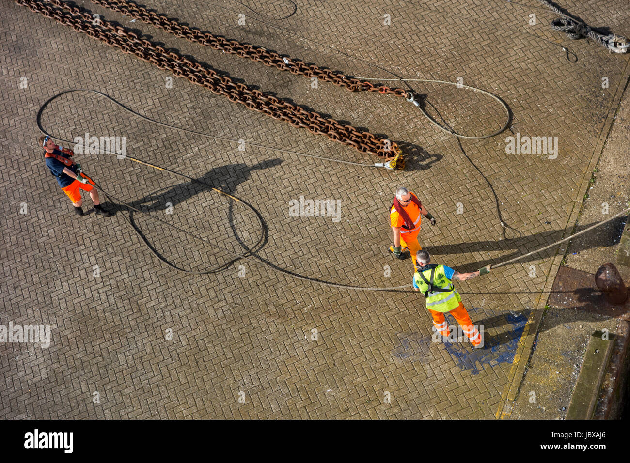 Hafenarbeiter anbringen vertäut Schiffs Trosse Shoreside Bitt auf Kai im Hafen dock Stockfoto