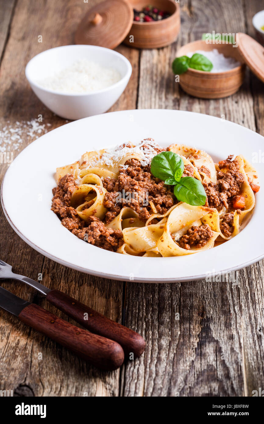 Pasta aus traditionellen italienischen Bandnudeln Bolognese mit Käse Grana Padana auf rustikalen Holztisch serviert Stockfoto