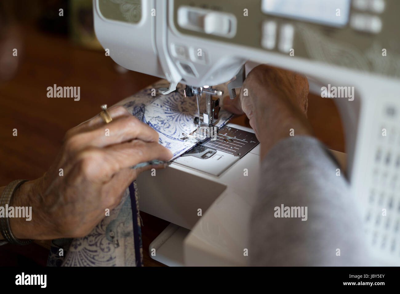 Mit 80 Jahren gerne MaryAnn noch Dinge mit ihrer Nähmaschine zu schaffen. Das Älterwerden hat dieses sehr kreativ Senior nicht gebremst! Stockfoto