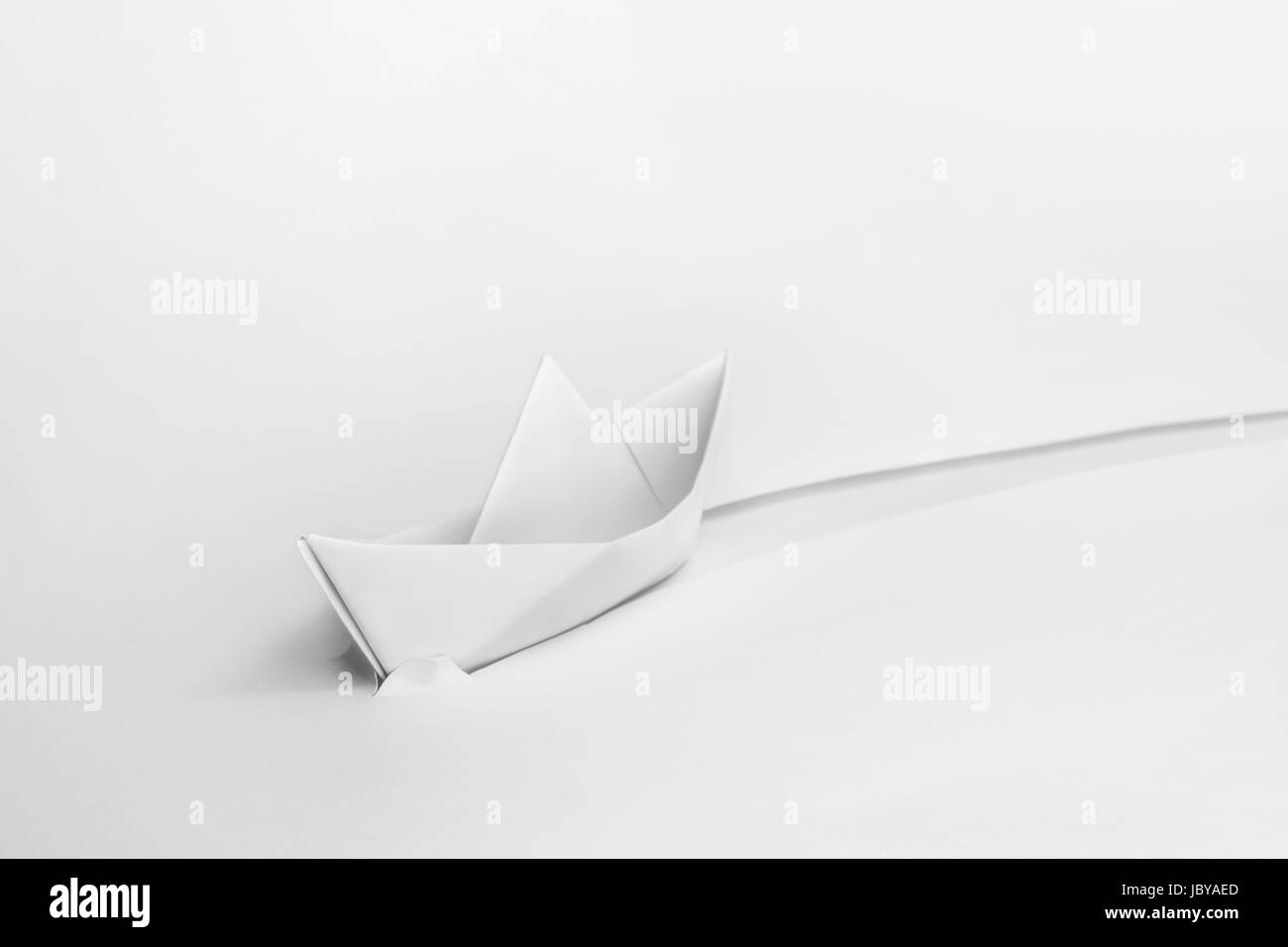 Weißes Papier Origami Boot durchschneidet Papier. Stockfoto