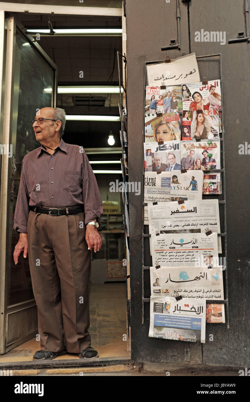 Der Besitzer eines langjährigen Buchhandlung im Hamra Viertel von Beirut steht in der Tür Rauchen einer Zigarette während der Nachbarschaft beobachten. Stockfoto
