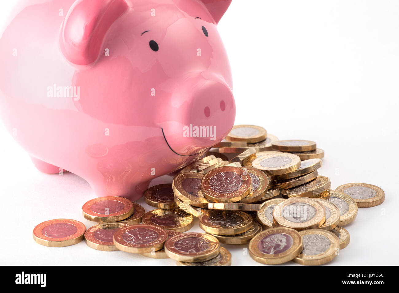 Sparschwein mit einem Haufen neuer Pfund-Münzen Stockfoto