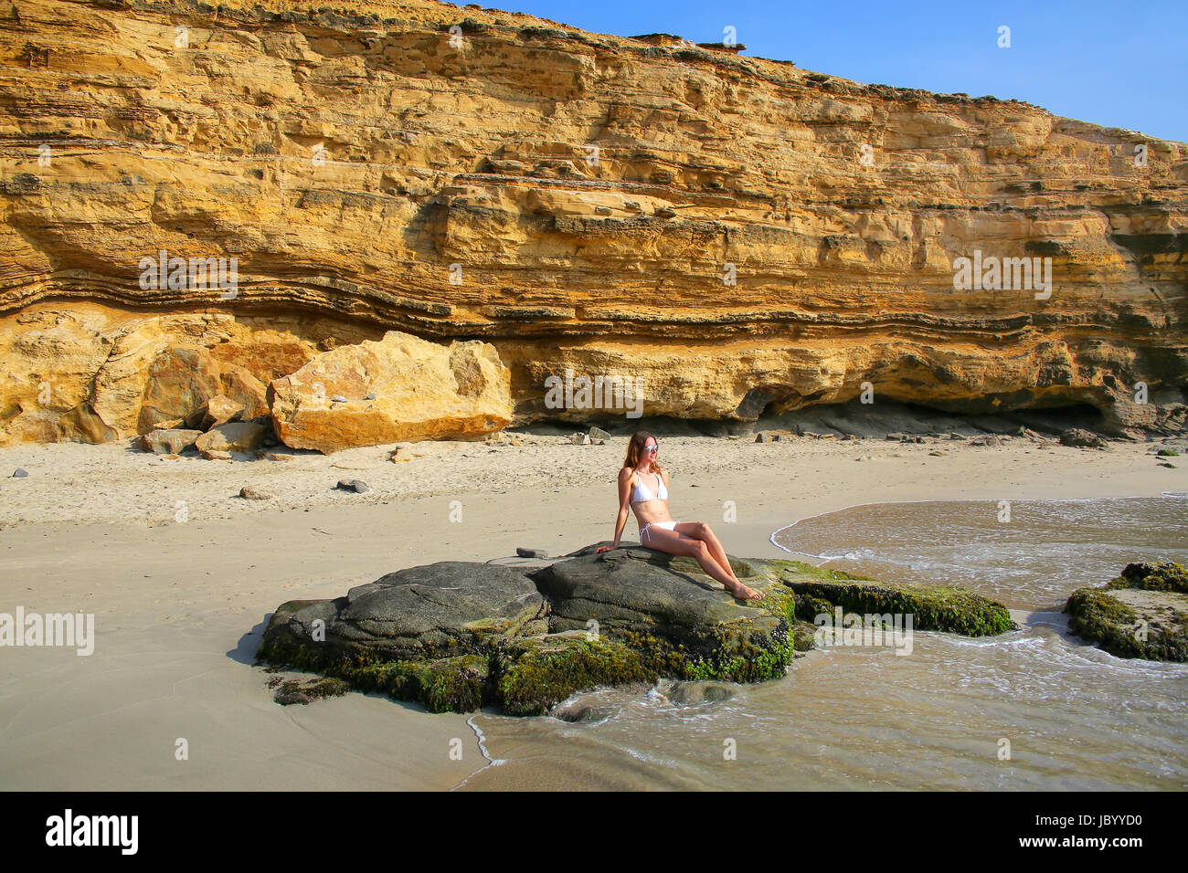 Junge Frau im Bikini sitzen am La Mina Beach in Paracas National Reserve, Peru. Hauptzweck des Reservats ist zum Schutz der marinen Ökosysteme und histo Stockfoto