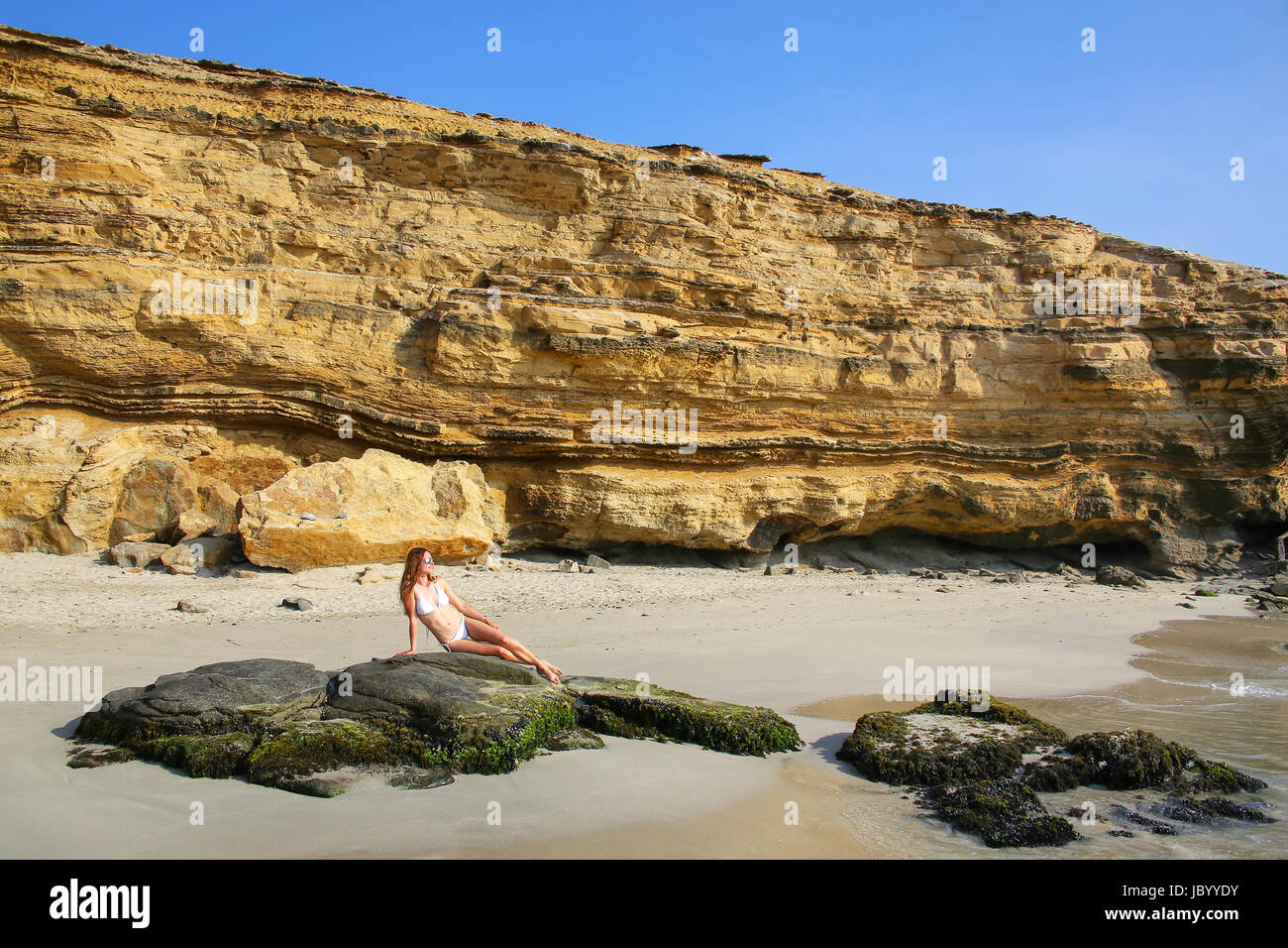 Junge Frau im Bikini sitzen am La Mina Beach in Paracas National Reserve, Peru. Hauptzweck des Reservats ist zum Schutz der marinen Ökosysteme und histo Stockfoto