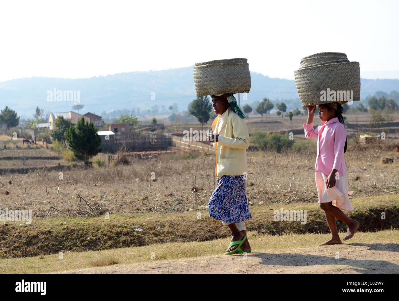 Frauen, die große Körbe auf dem Kopf im Zentrum von Madagaskar. Stockfoto