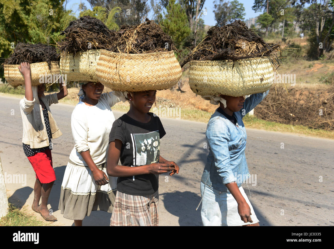 Madagassische Frauen, große Körbe voll von organischen Stoffen. Stockfoto