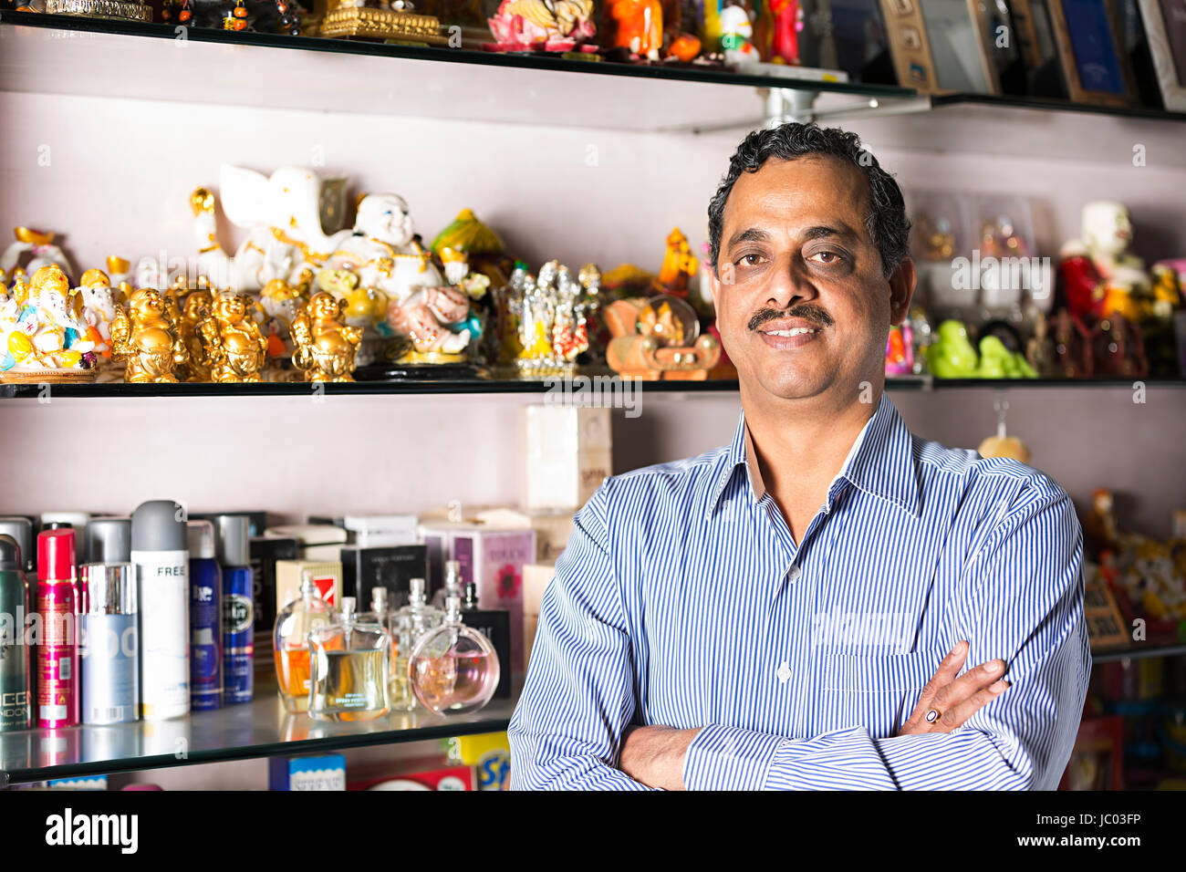 1 Indischer Ladenbesitzer Mann Arm gekreuzt stehen im Shop Stockfoto