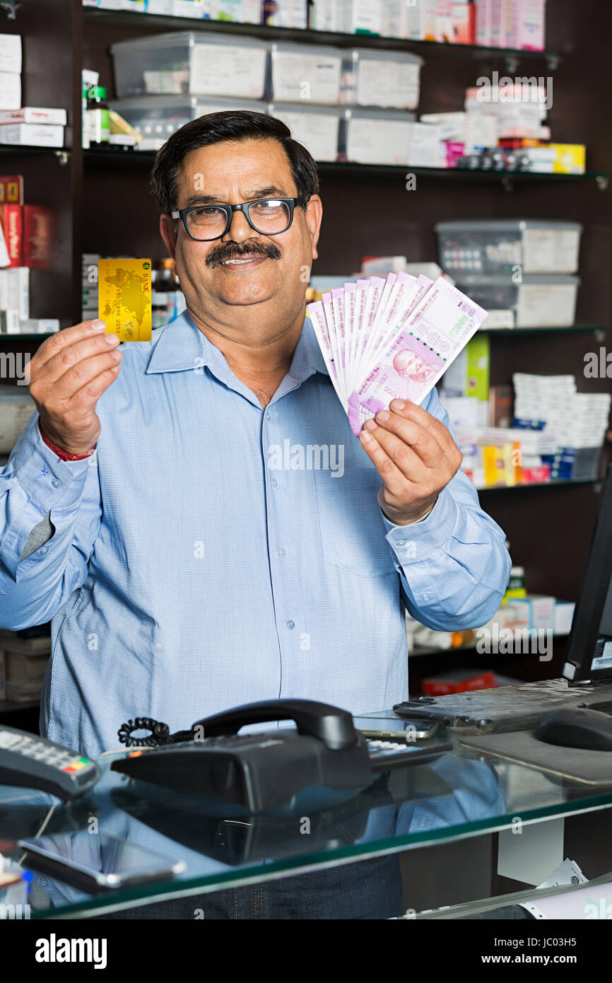 1 Indischer Ladenbesitzer Mann mit Geld Mit Kreditkarte in der Apotheke Stockfoto