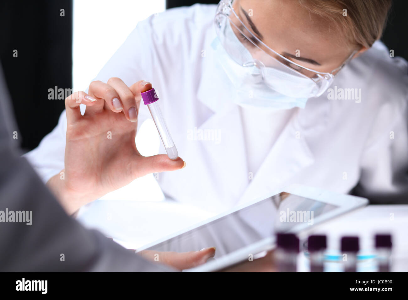 Nahaufnahme eines wissenschaftlichen Forschungsteam mit klare Lösung im Labor Stockfoto
