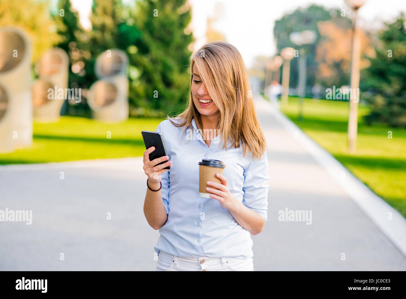Selbstbewusste Frauen lesen Informationen über Finanz-News während des Gehens in Unternehmen Flur während der Arbeit zu brechen, erfolgreiche Geschäftsfrau, die schreiben Text messa Stockfoto