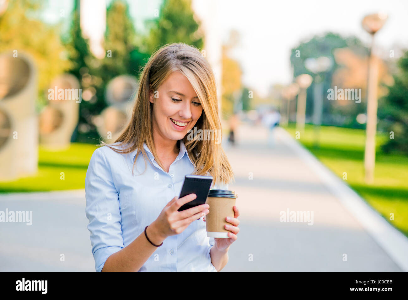 Selbstbewusste Frauen lesen Informationen über Finanz-News während des Gehens in Unternehmen Flur während der Arbeit zu brechen, erfolgreiche Geschäftsfrau, die schreiben Text messa Stockfoto