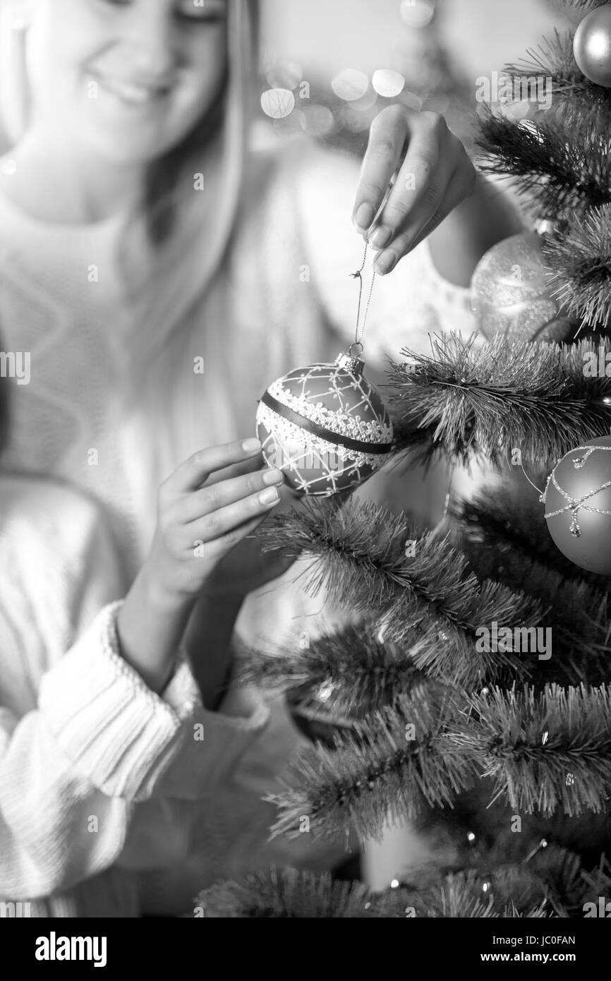 Closeup schwarz-weiß Bild Tochter helfende Mutter in dekorieren Weihnachtsbaum Stockfoto