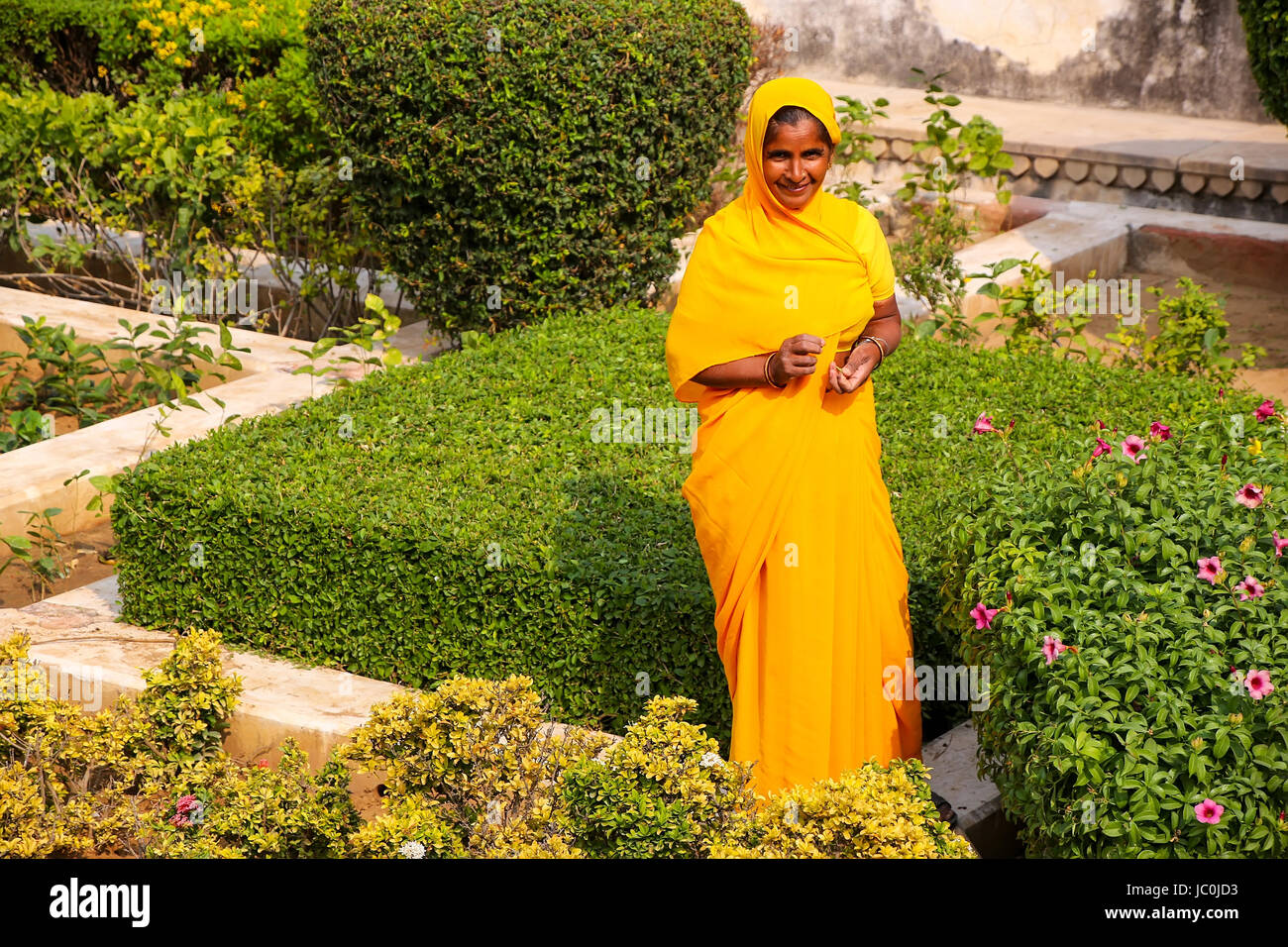 Frau zu Fuß durch den Garten im dritten Hof des Amber Fort, Rajasthan, Indien. Amber Fort ist die wichtigste touristische Attraktion in der Umgebung von Jaipur. Stockfoto