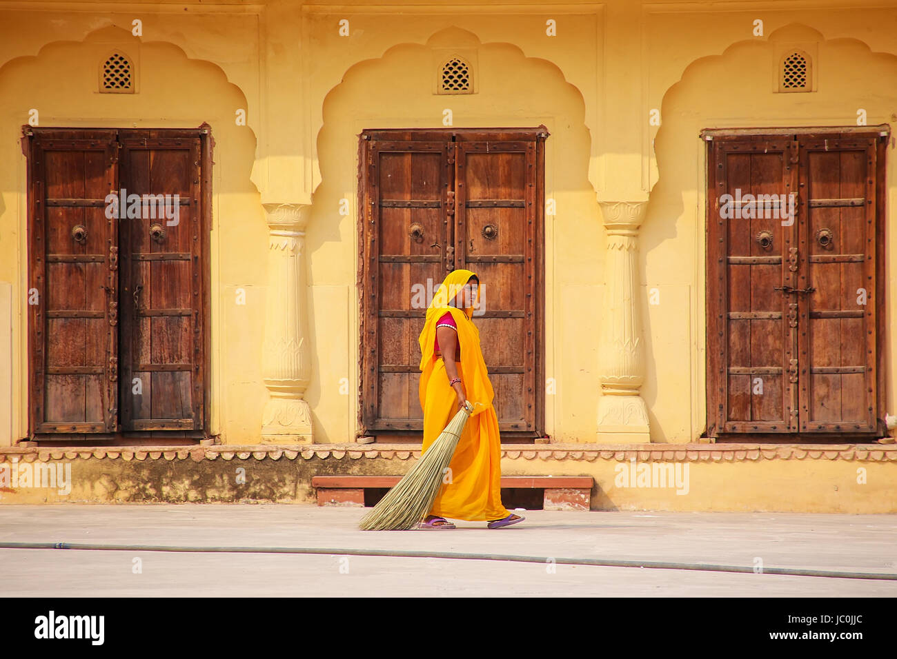 Frau fegt im zweiten Hof des Amber Fort, Rajasthan, Indien. Amber Fort ist die wichtigste touristische Attraktion in der Umgebung von Jaipur. Stockfoto