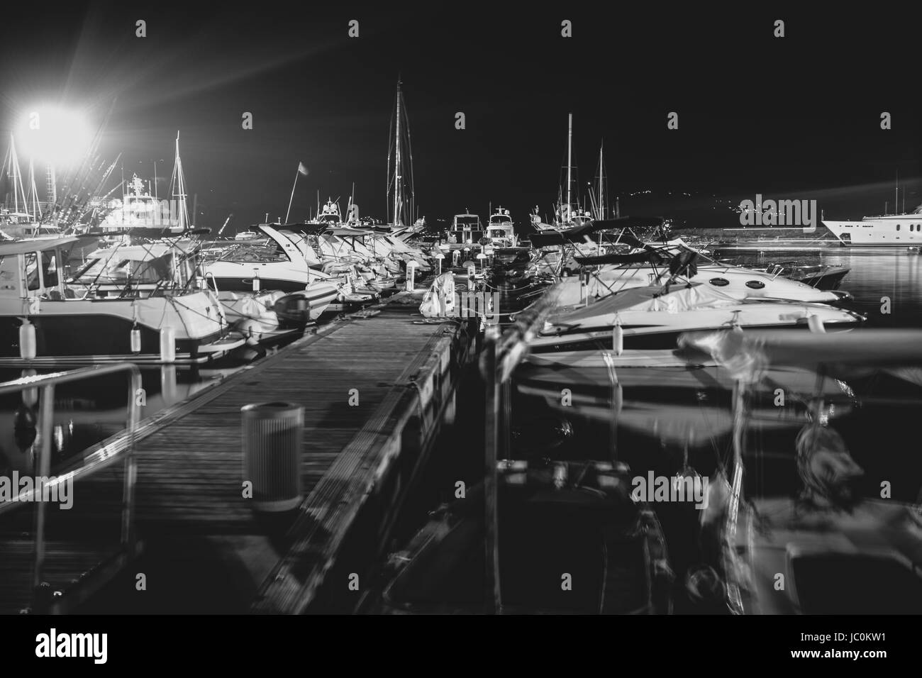 Schwarz / weiß Foto von Pier mit Ankern Motorboote am späten Abend Stockfoto