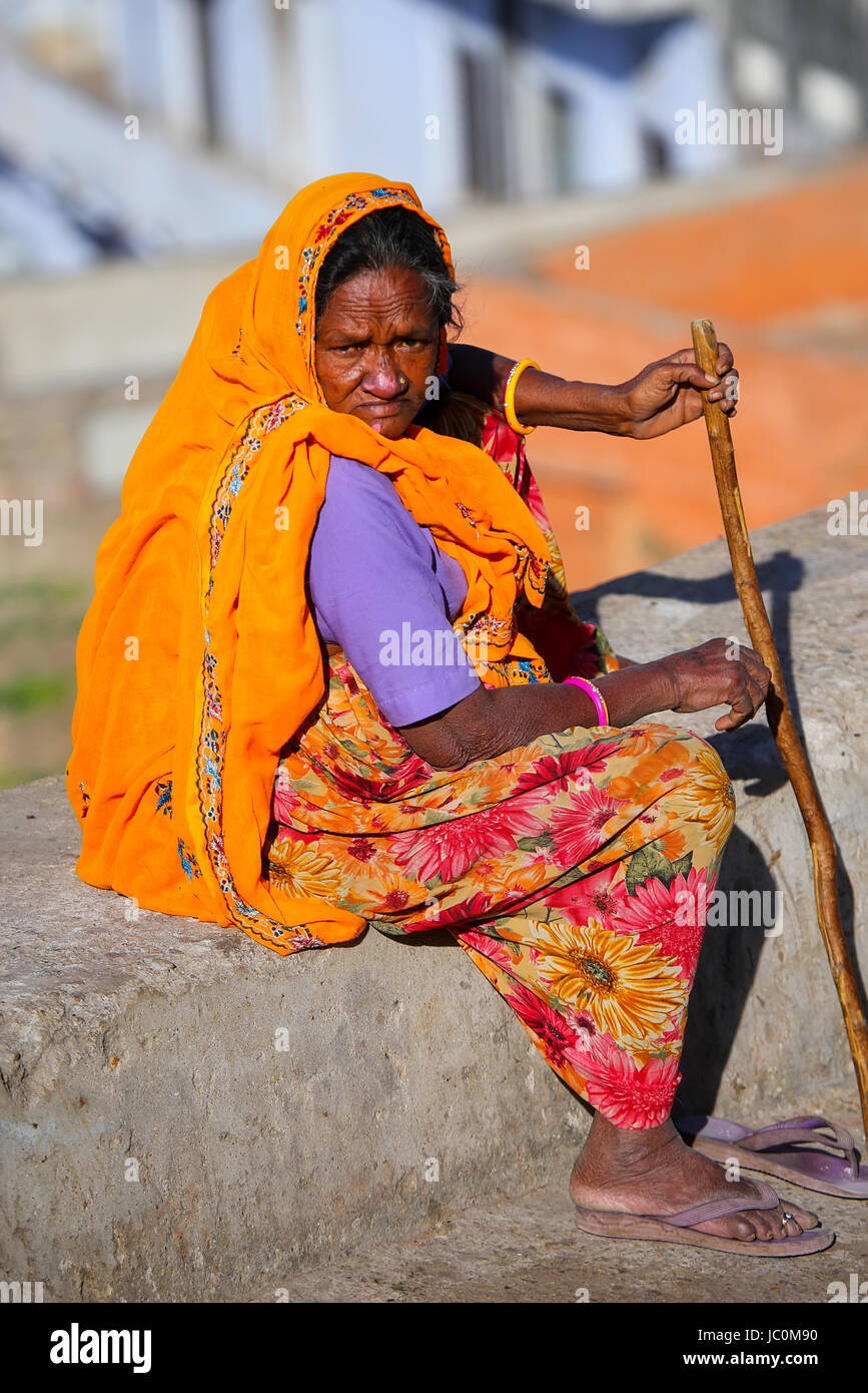 Frau im bunten Sari sitzt auf einer Steinmauer, Jaipur, Indien. Jaipur ist die Hauptstadt und größte Stadt im indischen Bundesstaat Rajasthan. Stockfoto