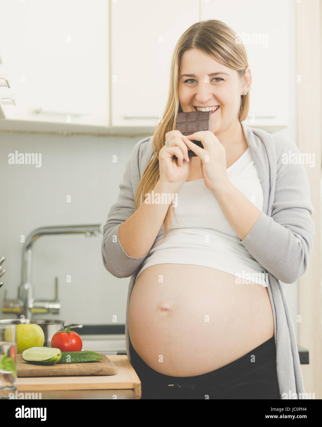 Porträt von lächelnden schwangere Frau Schokolade essen Stockfoto