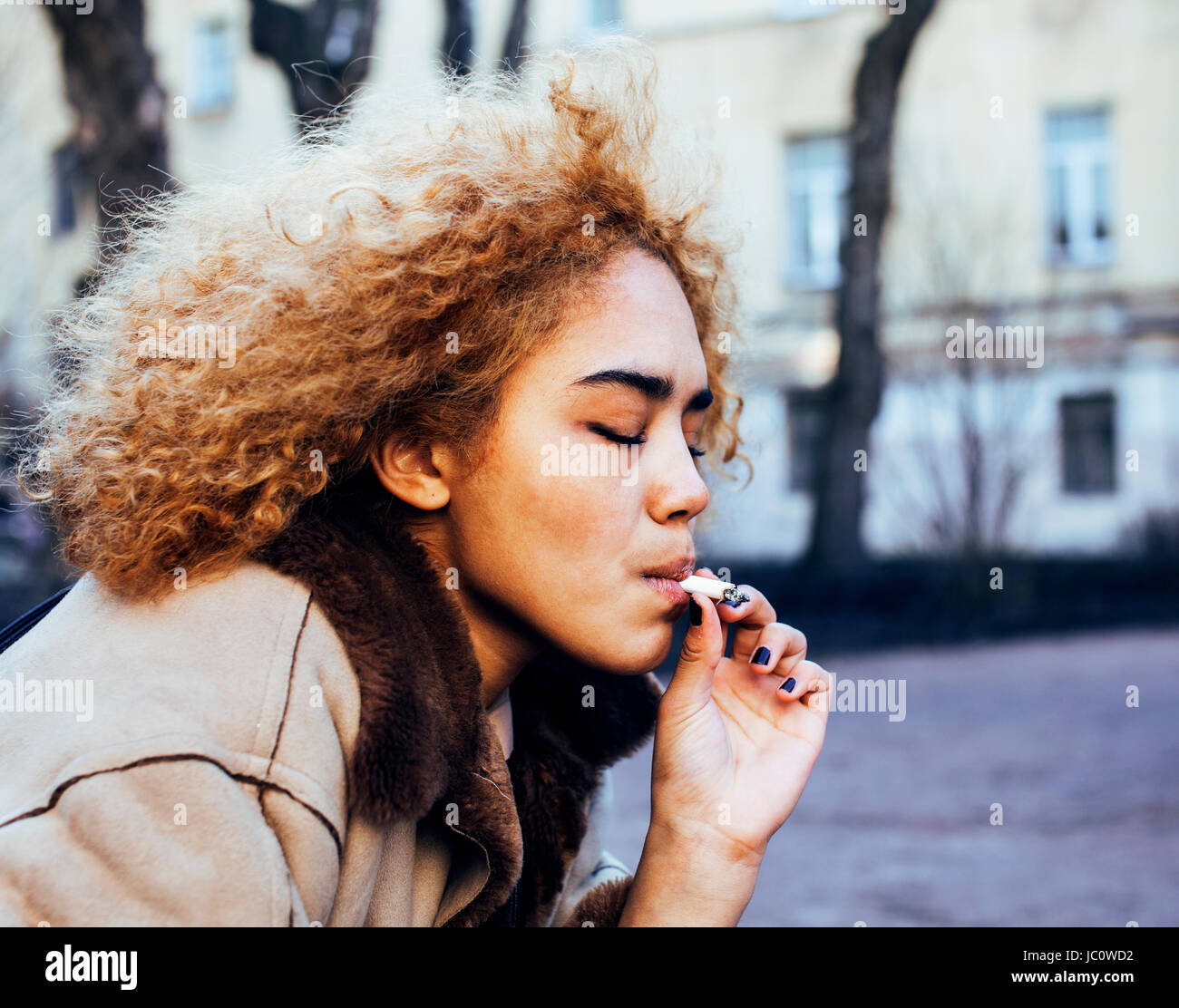 junges hübsches Mädchen Teenager außerhalb qualmender Zigarette hautnah, lo Stockfoto