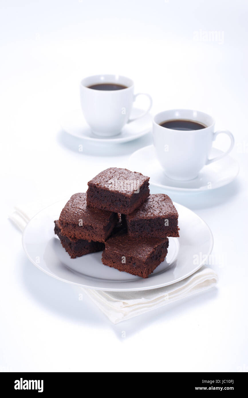 Schokoladen-Brownies auf weißen Teller und zwei Tassen Kaffee Stockfoto