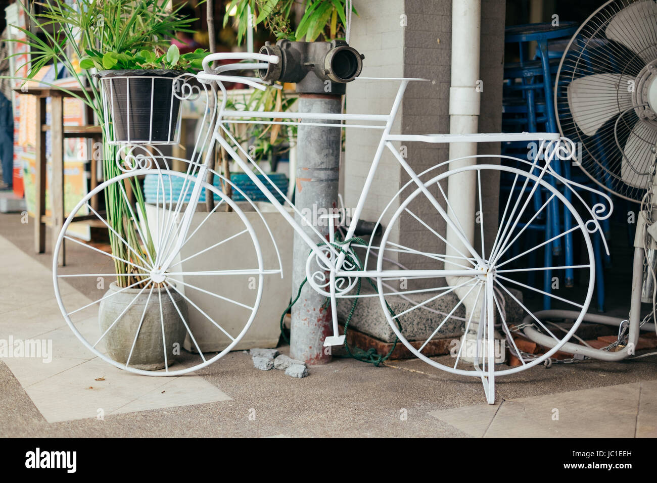 Weiße Bycycle mit Wassertank und grünes Blatt. Stockfoto