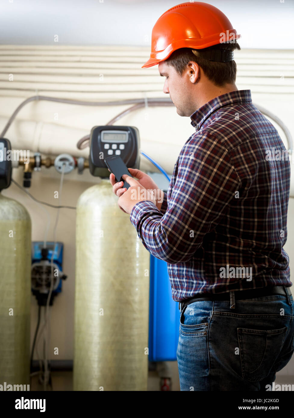 Junge Ingenieurin unter Zählerstände von Industriepumpen werkseitig Stockfoto