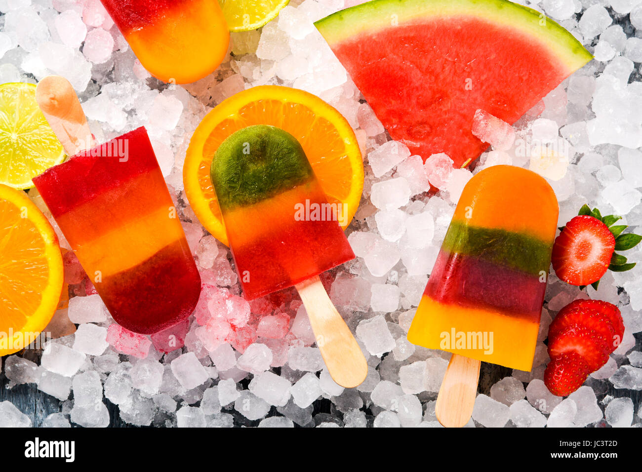 High-Angle Shot von einigen verschiedenen hausgemachten Eis erscheint, gemacht mit verschiedenen natürlichen Fruchtsäften und Stücke von Früchten wie Wassermelone, Zitrone, Pfirsich, l Stockfoto