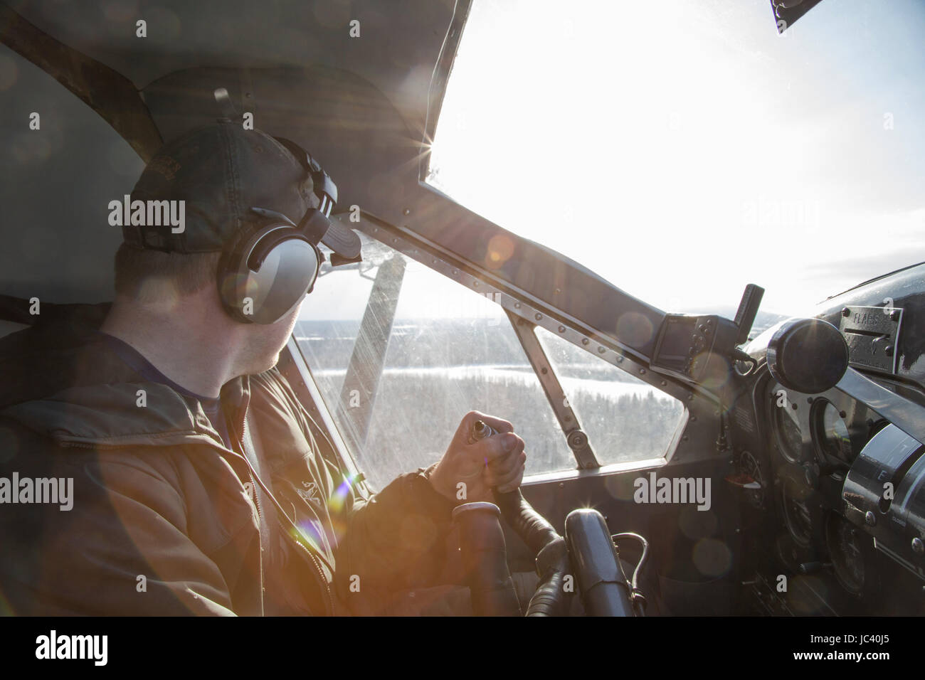 Ein Buschpilot schaut aus seinem Fenster während des Fluges durch die Wildnis Alaskas. Stockfoto