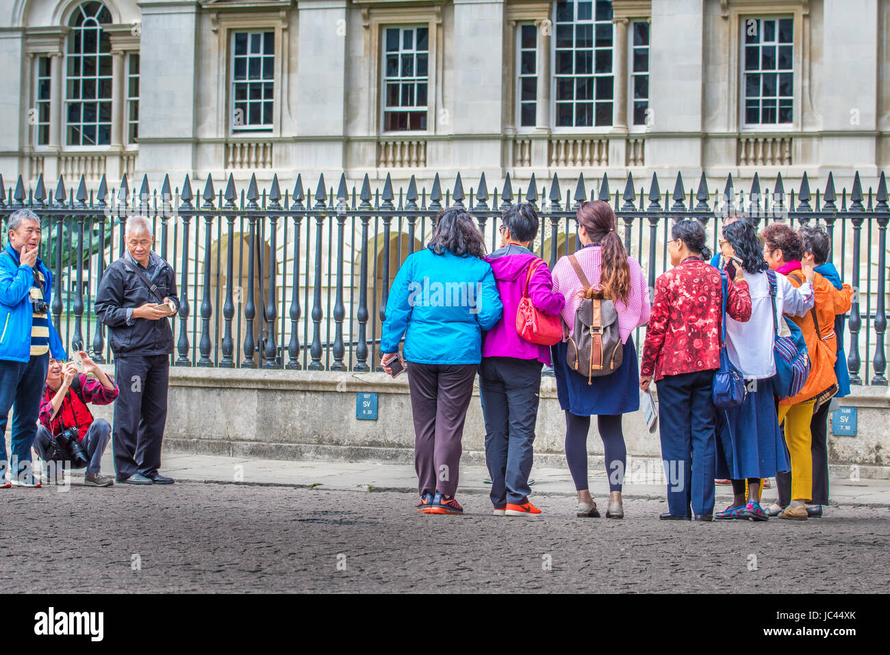 Gruppe von chinesischen TouristInnen Pose für ein Foto vor dem Geländer des Senat-Haus, Universität Cambridge, England, UK. Stockfoto