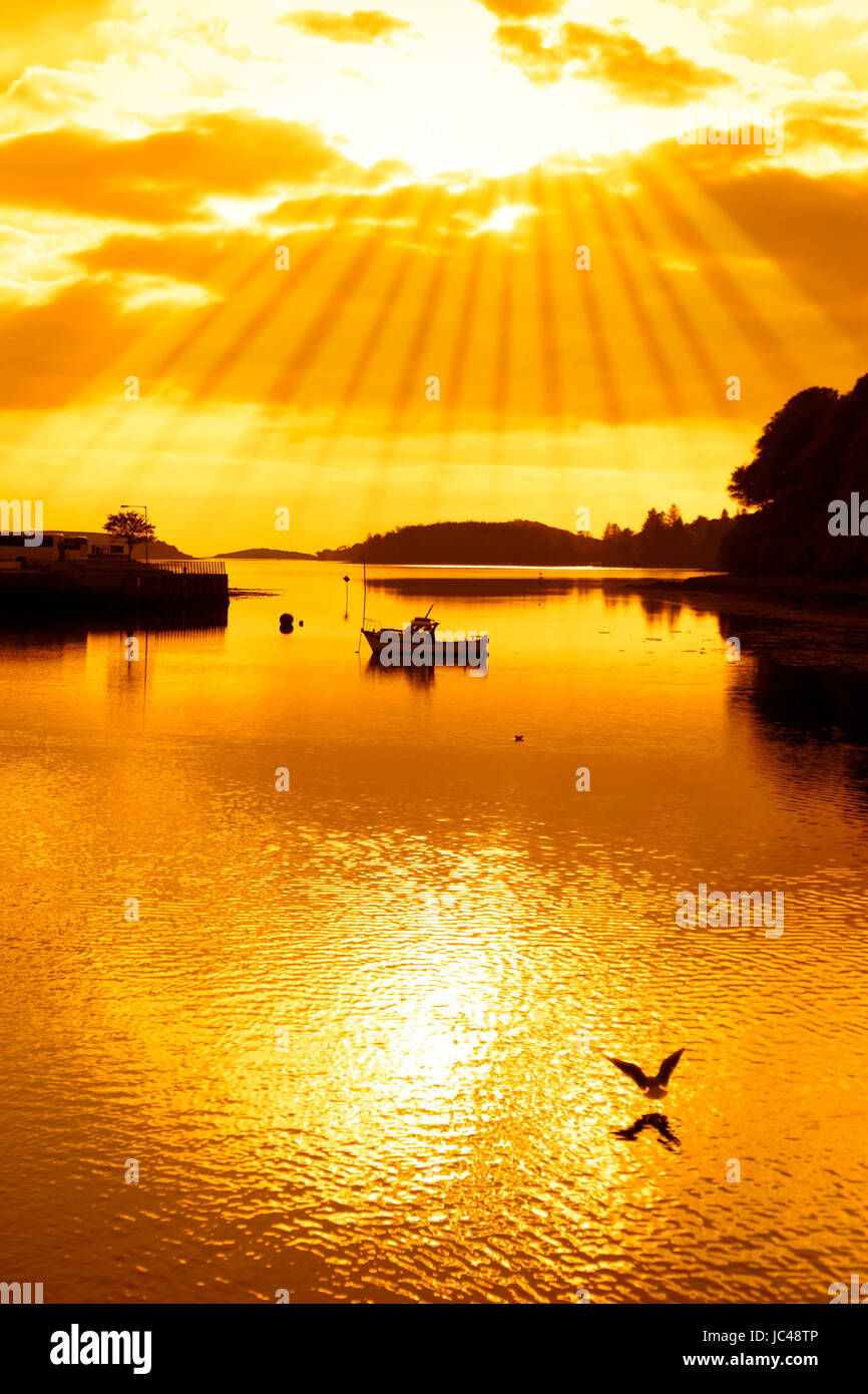 warme orange Silhouette des Bootes und Vögel bei Sonnenuntergang über dem Fluss Eske in Donegal Stadt County Donegal Ireland Stockfoto