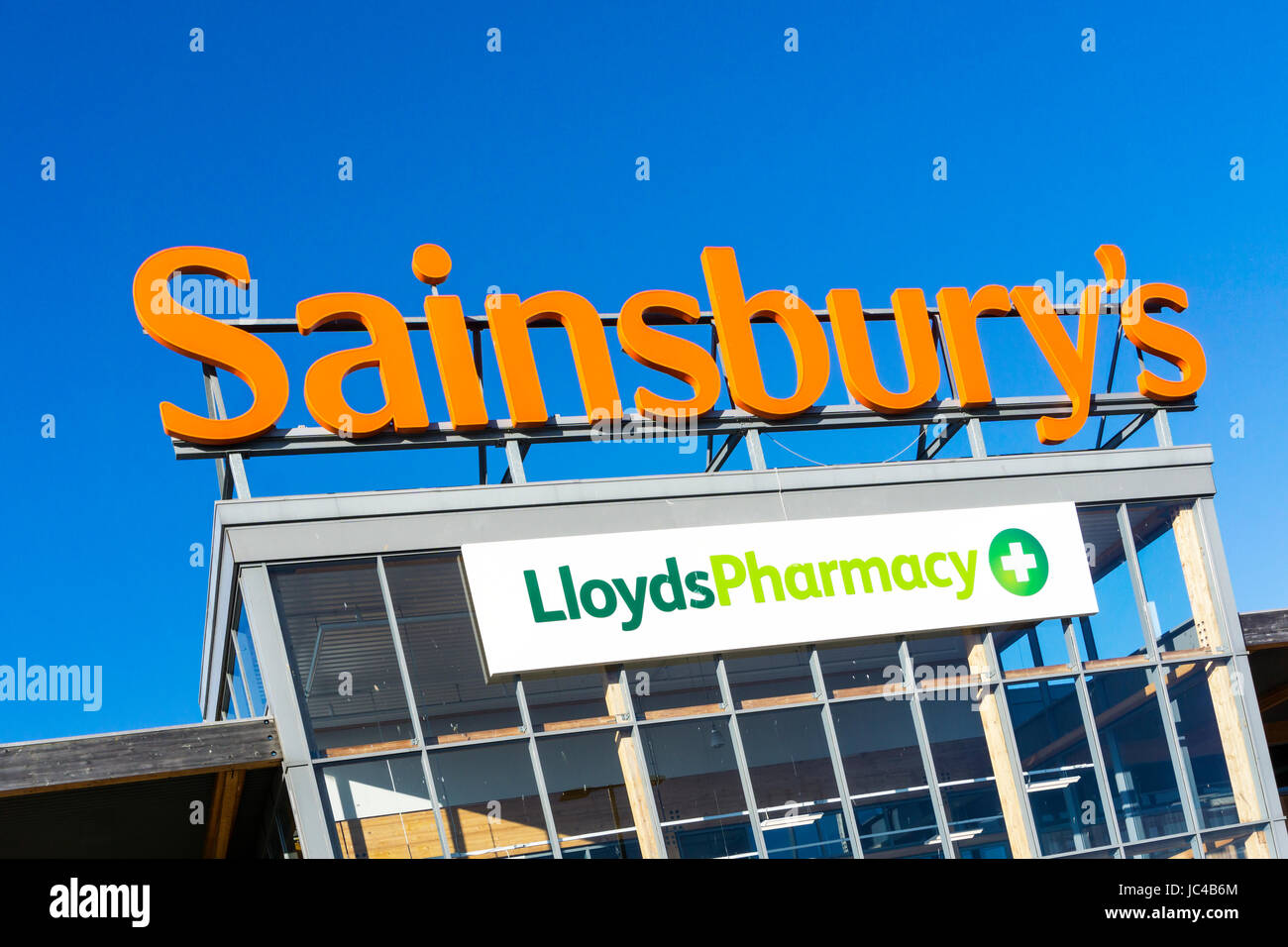 Ein Zeichen für Sainsbury's und Lloyds Pharmacy auf einem großen Sainsbury's Supermarkt in King's Lynn, Norfolk. Stockfoto