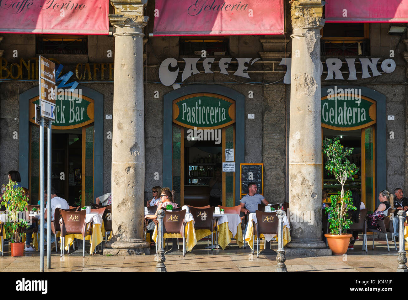 Cagliari Via Roma, Blick auf die Menschen, die sich im Sommer an Tischen auf einer Arkadenterrasse außerhalb des Caffe Torino im Marina-Viertel von Cagliari entspannen, Stockfoto