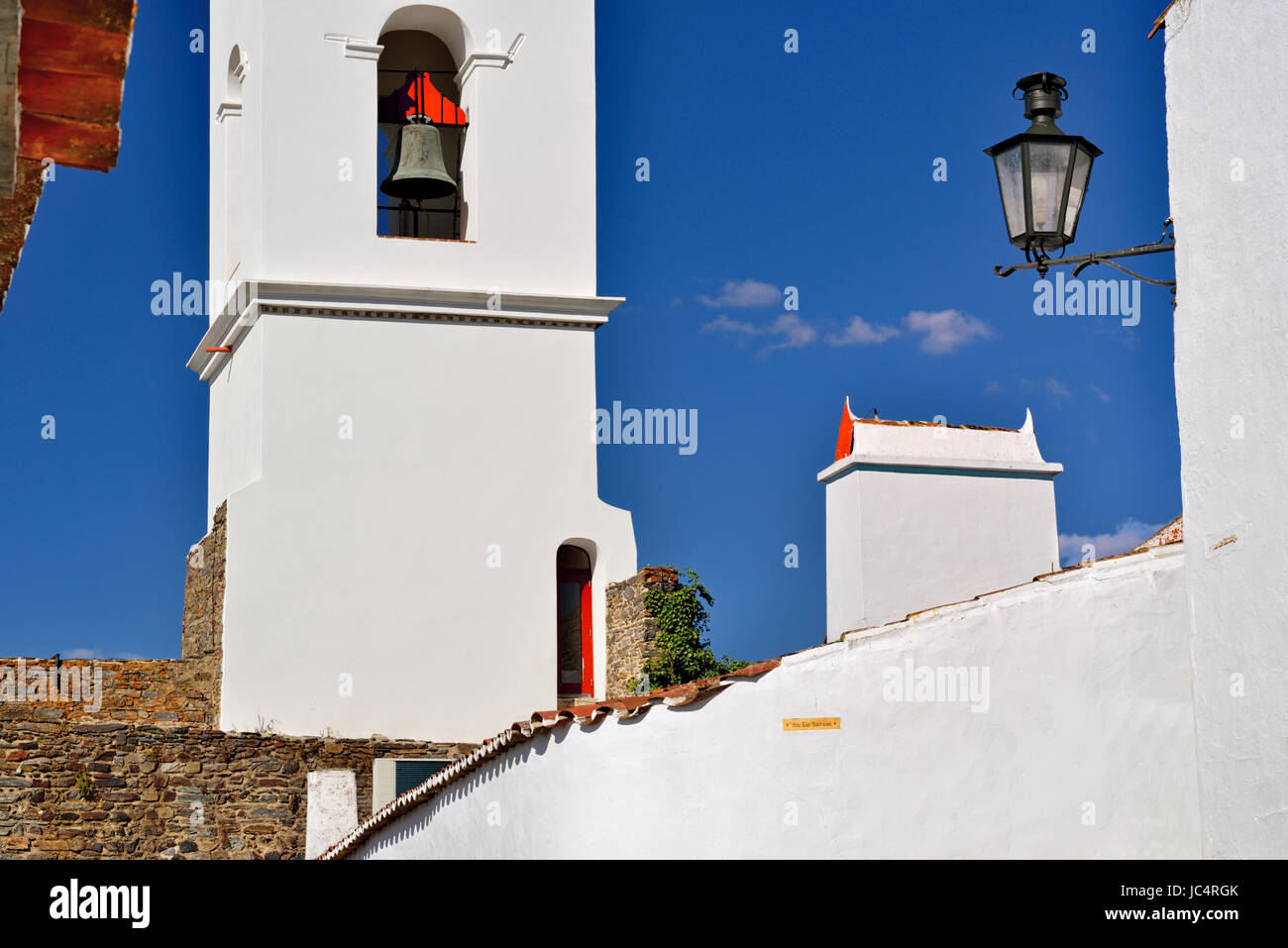 Glockenturm, Schornstein und Straßenleuchte mit blauem Himmel weiß gewaschen Stockfoto