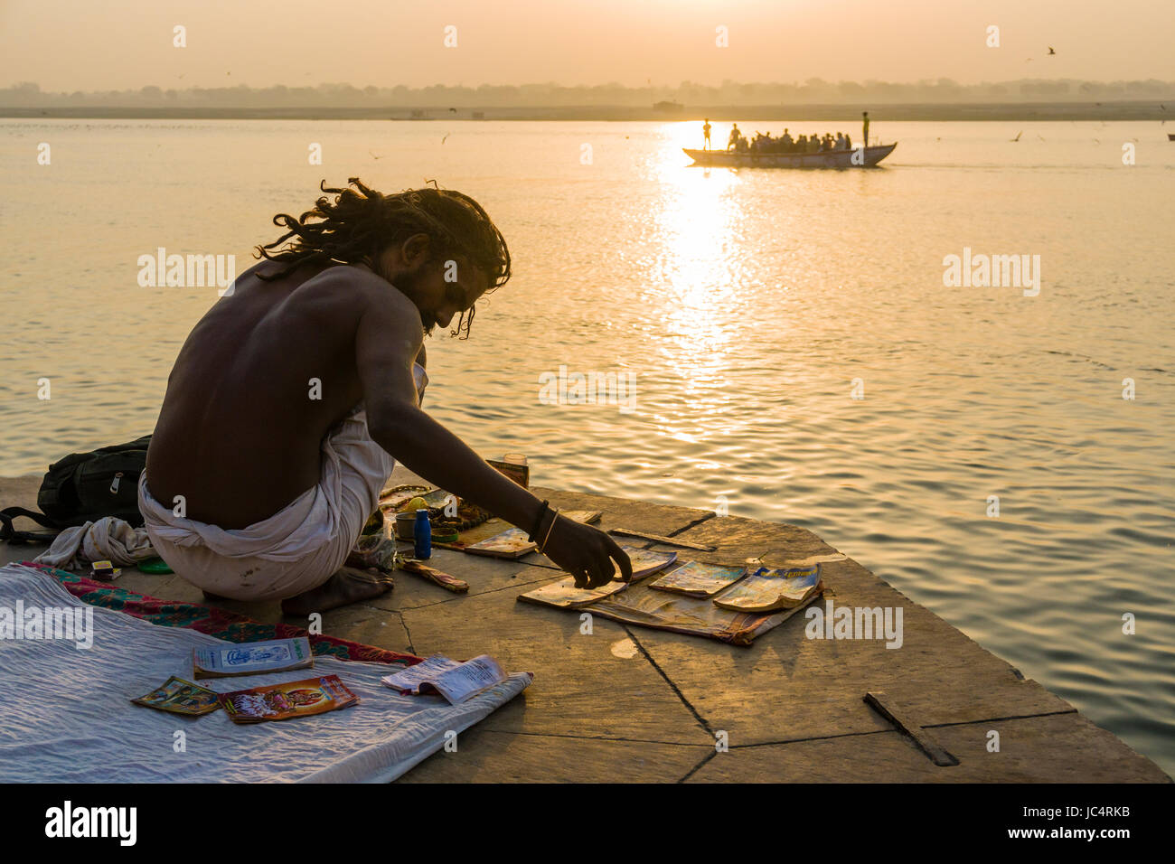 Ein sadhu, heiliger Mann, bereitet sich auf ein religiöses Ritual, das auf einer Plattform am heiligen Fluss Ganges Meer Ghat im Vorort godowlia Stockfoto