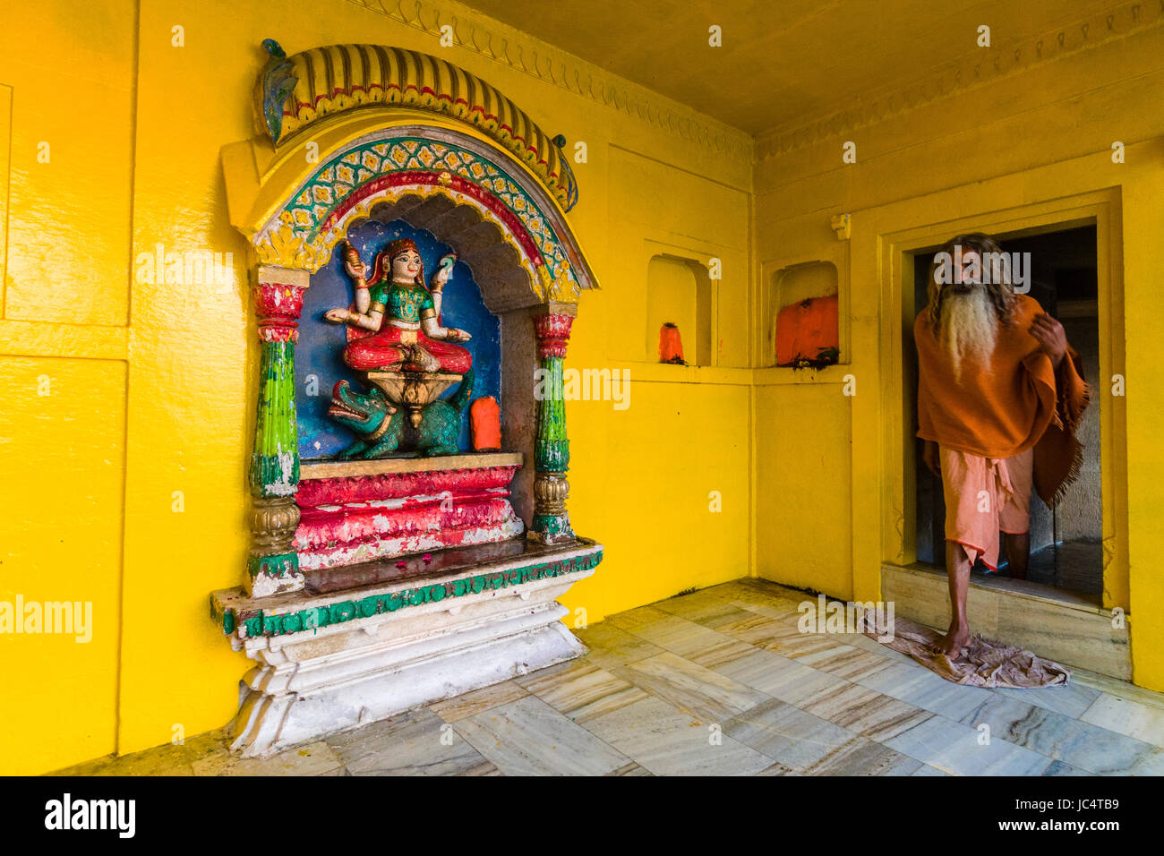 Ein sadhu, heiliger Mann, ein kleiner Tempel der Göttin Ganga am heiligen Fluss Ganges lalita Ghat gewidmet in der Vorstadt godowlia Stockfoto