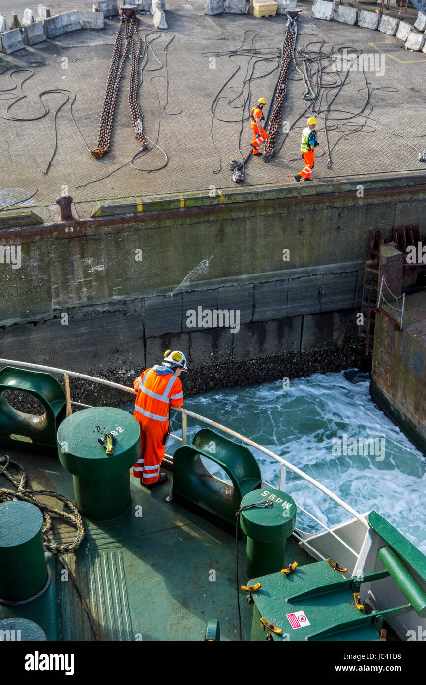 Weibliches Besatzungsmitglied in Orange insgesamt und tragen Schutzhelm arbeiten an Deck von Autotransporter / Frachtschiff im Hafen dock Stockfoto