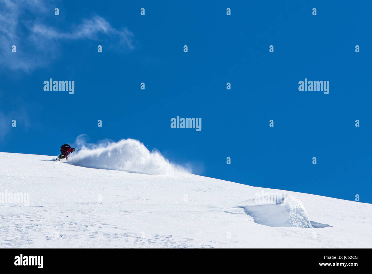 Professionelle Snowboarder Helen Schettini, reitet Neuschnee an einem sonnigen Tag beim Snowboarden in Haines, Alaska. Stockfoto