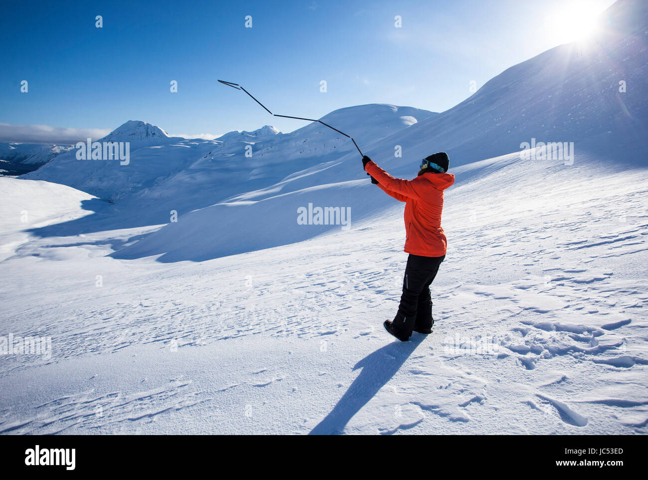Professionelle Snowboarder Robin Van Gyn, veranschaulicht, wie eine Lawinensonde an einem sonnigen Tag in Haines, Alaska. Stockfoto