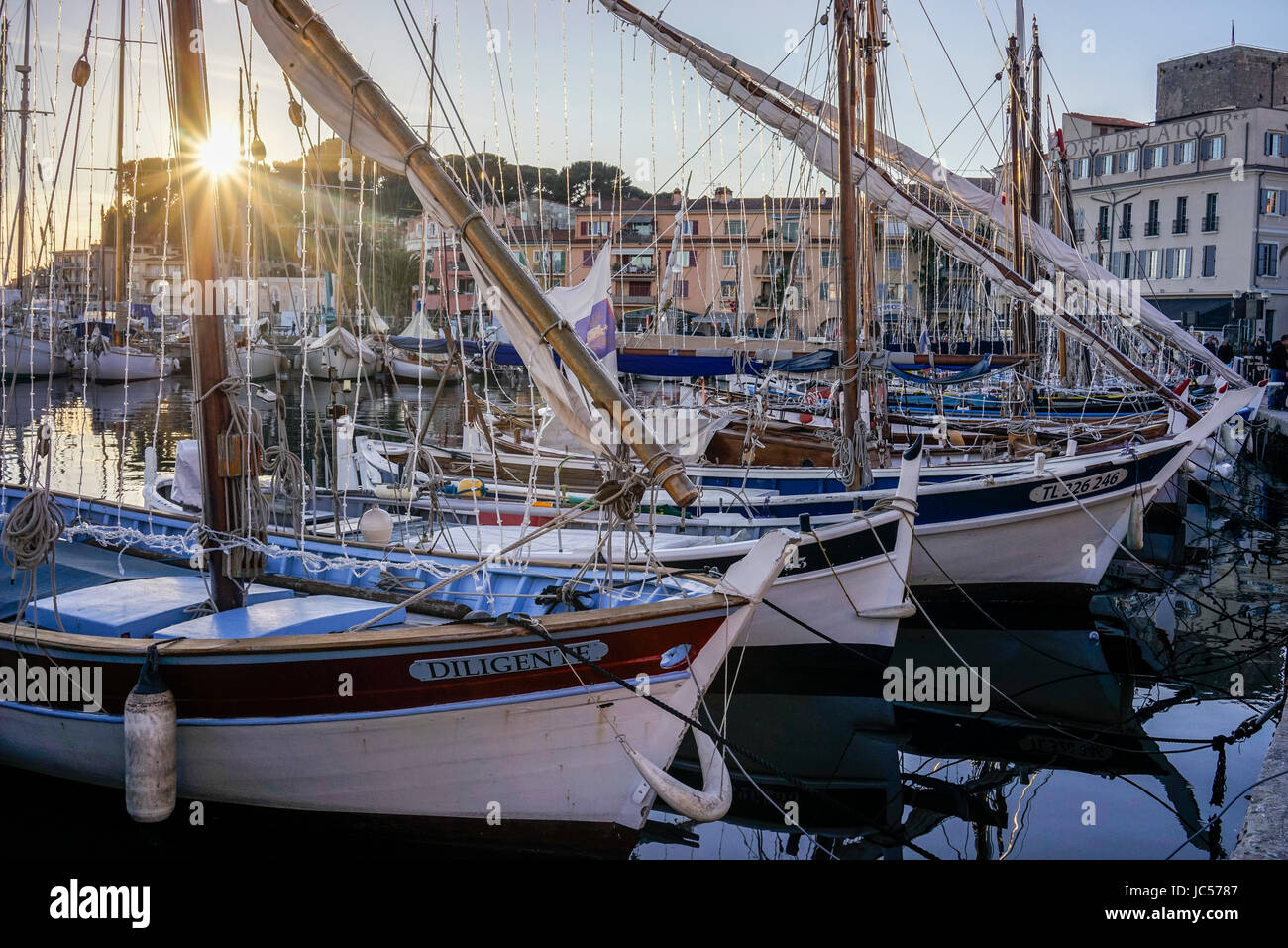 Winter-Sonnenuntergang über dem Hafen von Sanary-Sur-Mer in Südfrankreich mit mehreren Booten andocken, unter welche drei Holzboote im Vordergrund des Bildes. Stockfoto