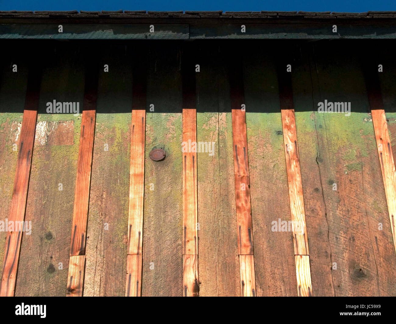 An der Seite einer Scheune mit Graten und Moos Stockfoto